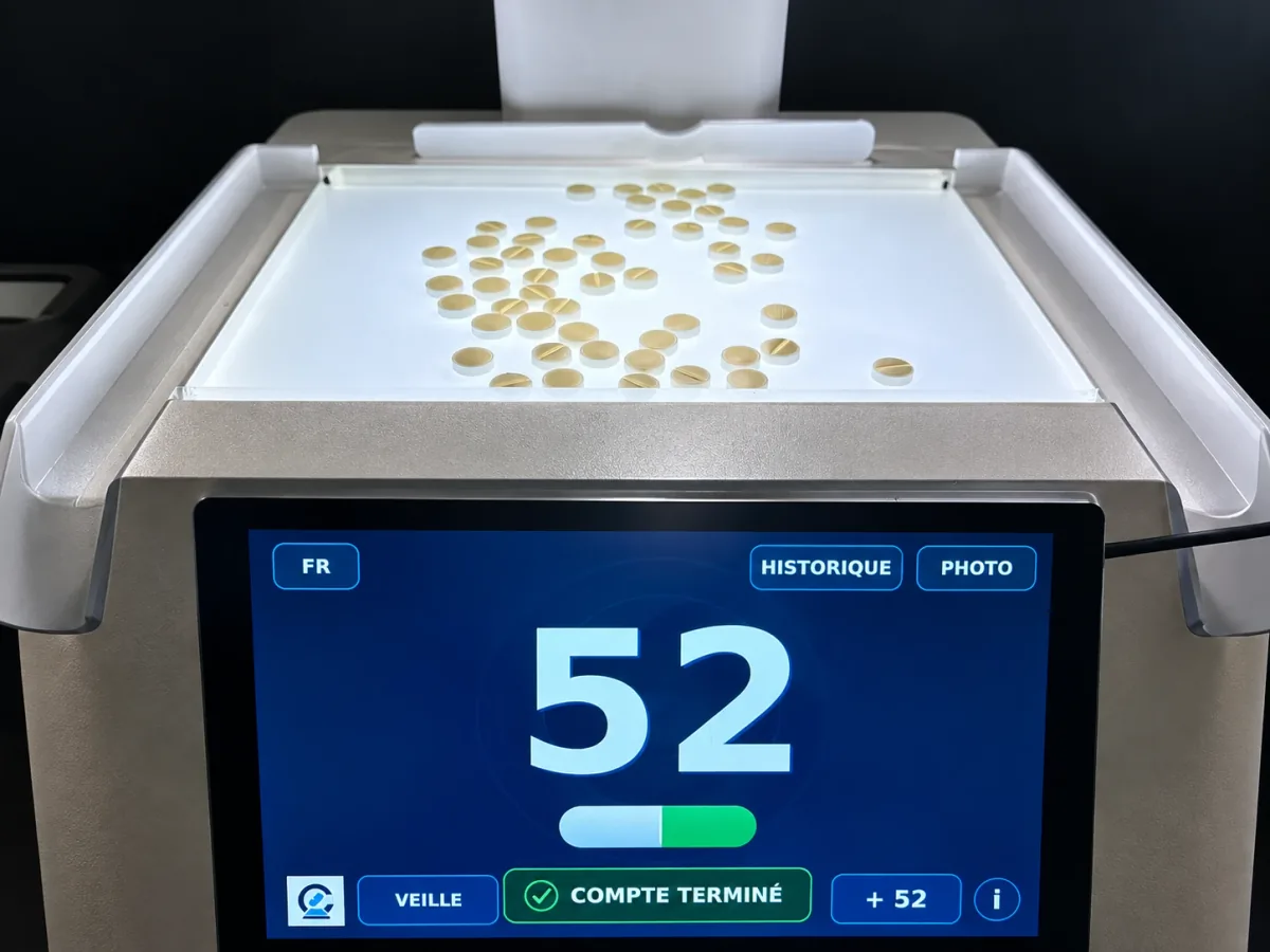 Plateau lumineux d'OptiCount rempli de comprimés, l'écran affichant 52 et la mention « Compte terminé »